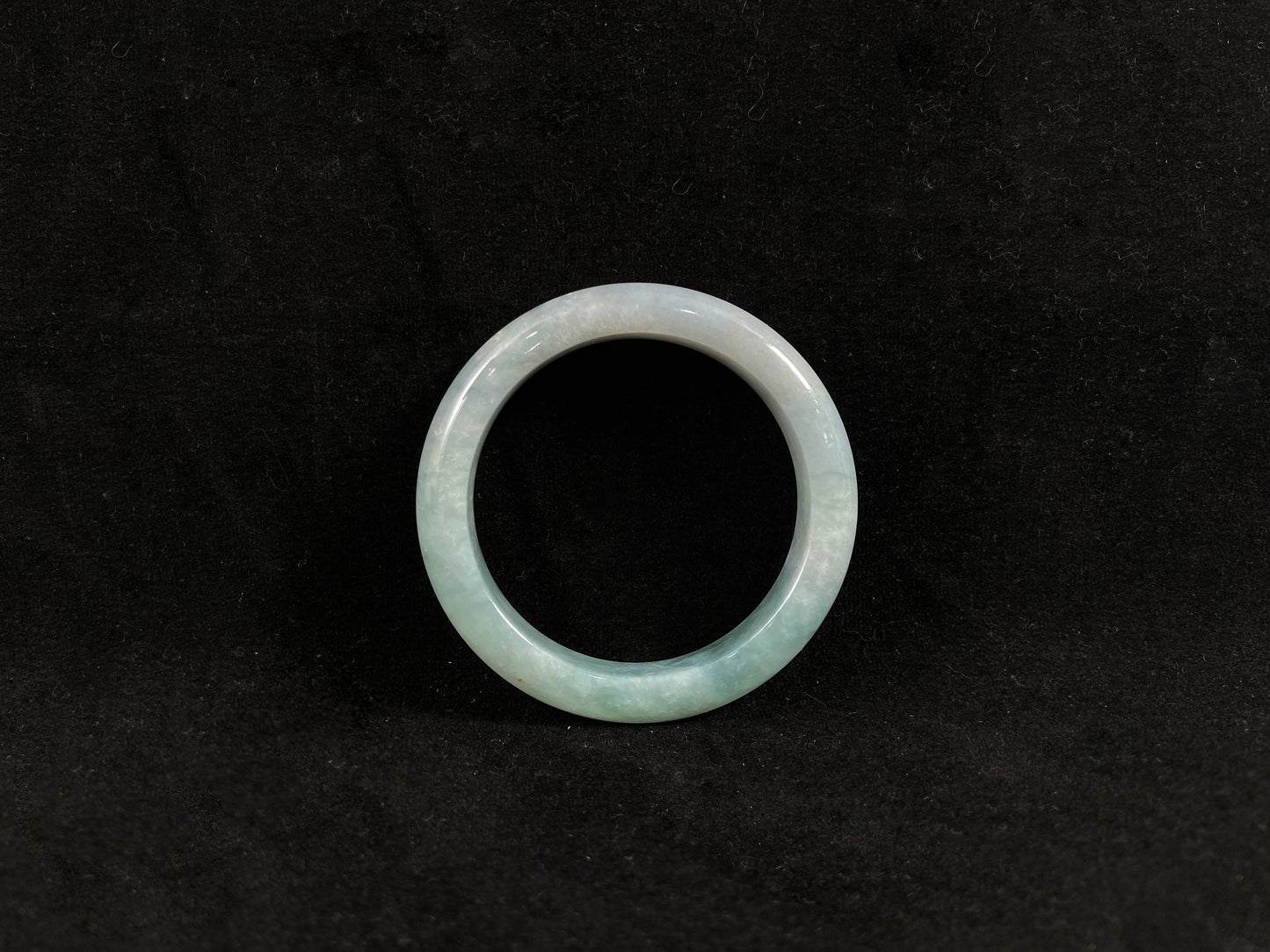 Green jade ring on a black background