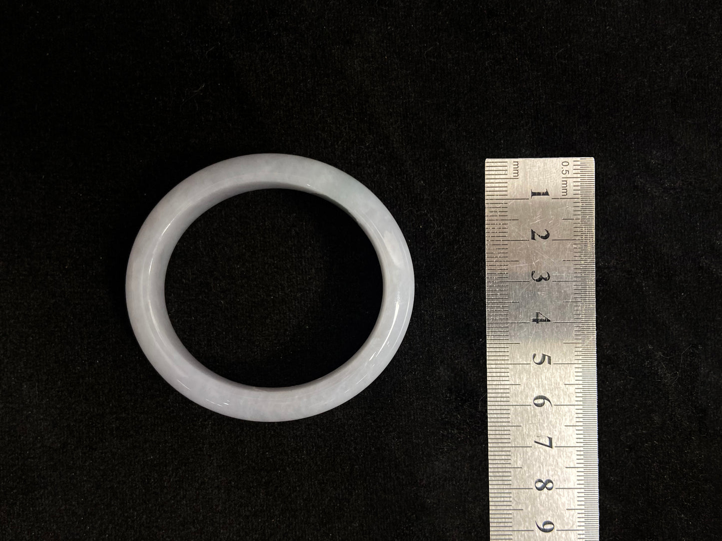 This jade bangle features a creamy white oval shaped Guifei design, known for its elegant and comfortable fit.