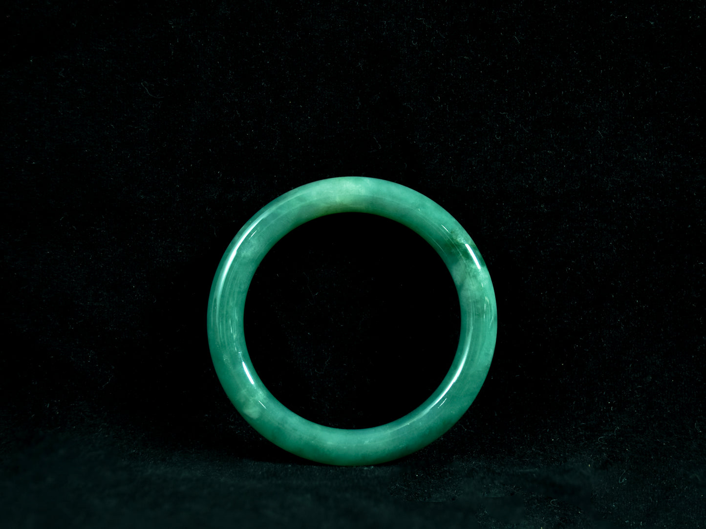 Green jade ring on a black background