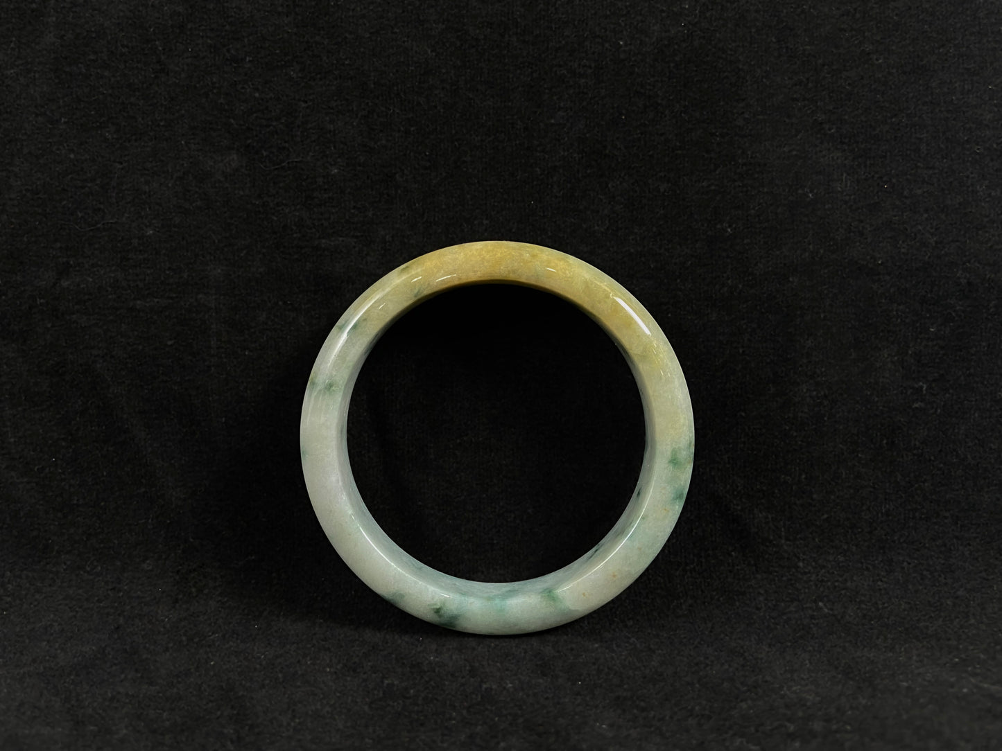 Green jade ring on a black background