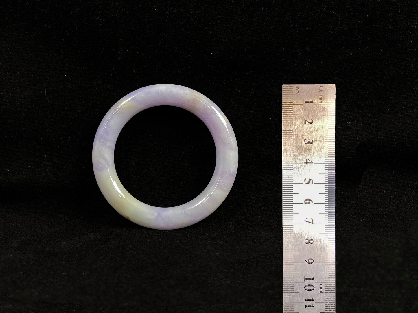 An elegant purple jadeite bangle delicately adorned with gold accents.