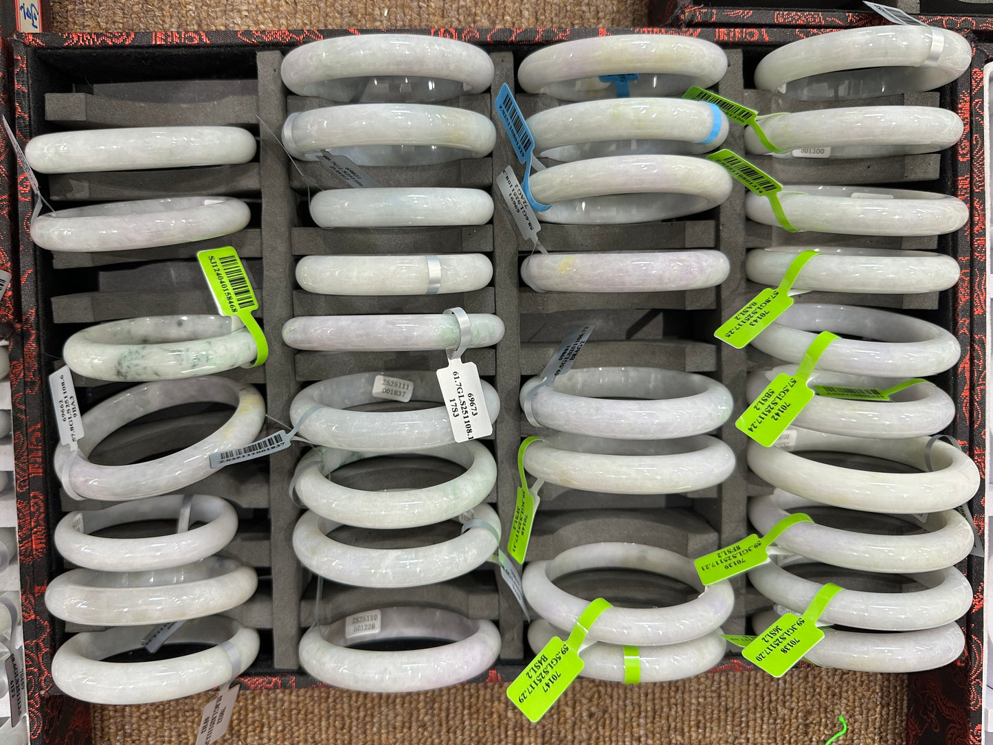 This jadeite bangle blends white and pale purple with golden accents.