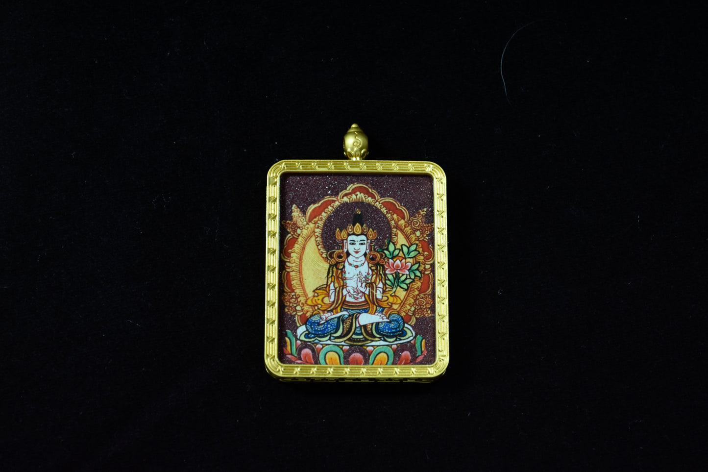 Decorative pendant with a figure in a gold frame on a black background
