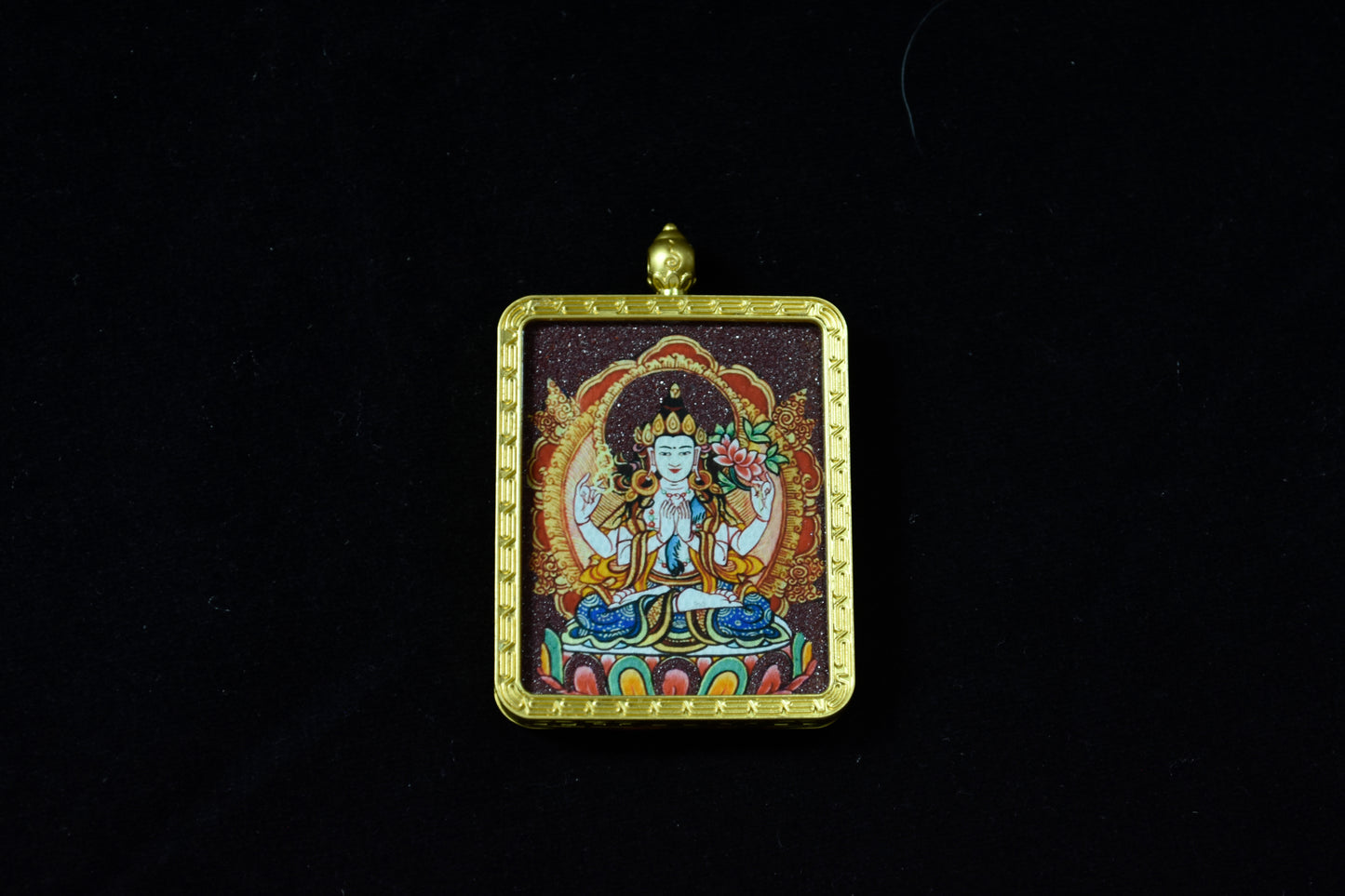 Decorative pendant with a central figure on a black background