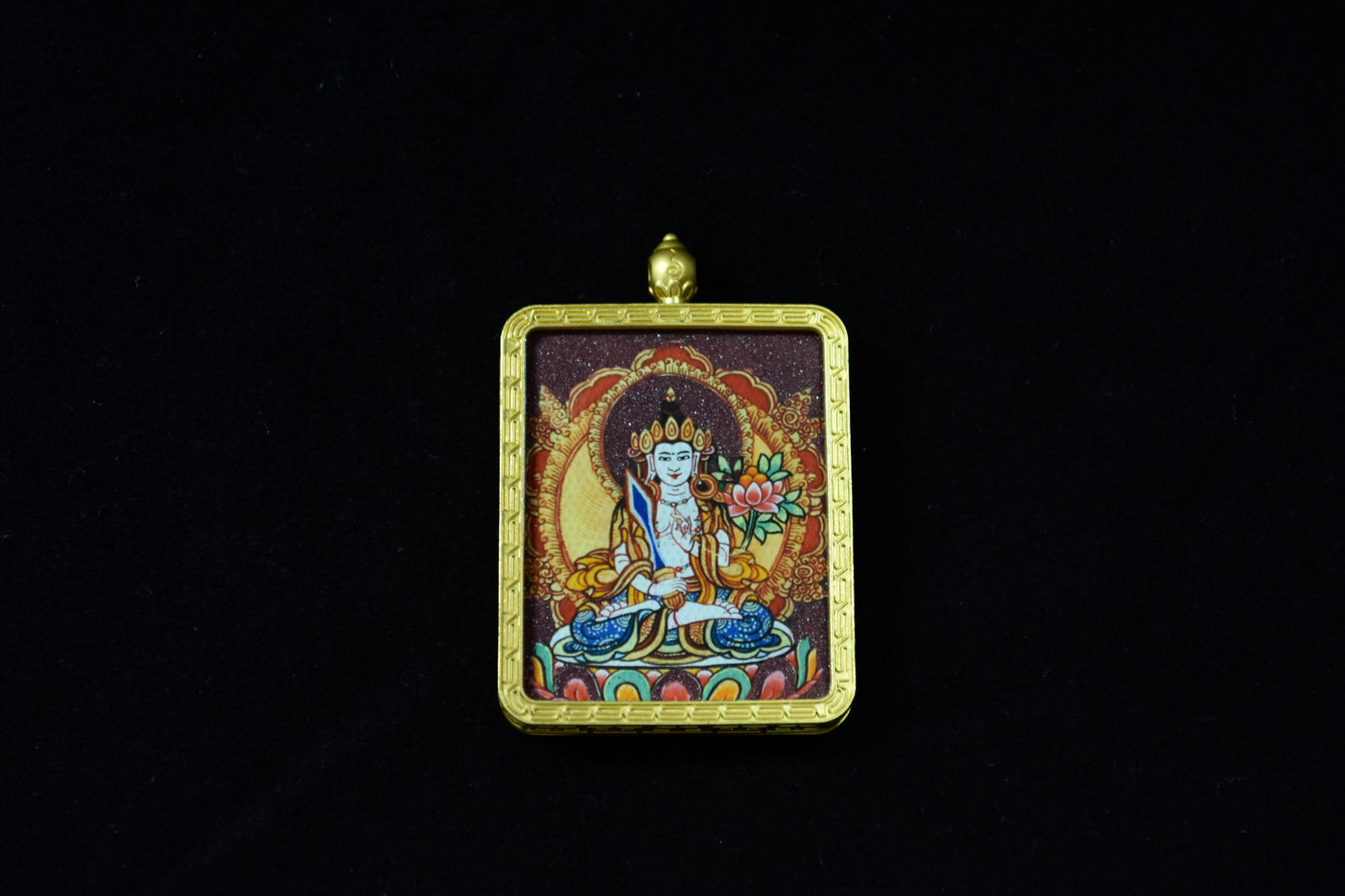 Decorative pendant with a figure in a gold frame on a black background