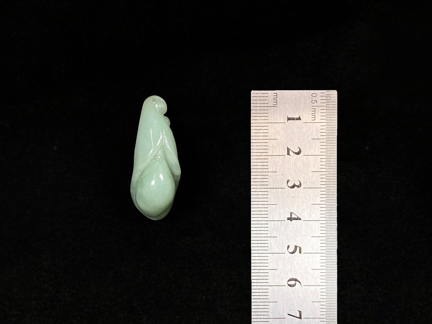 A light green jadeite magnolia bud carving.