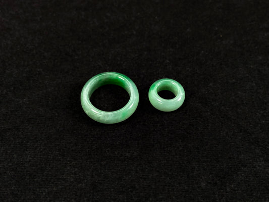 A loose jadeite with a light green base and vibrant green mother-child pendant accents.