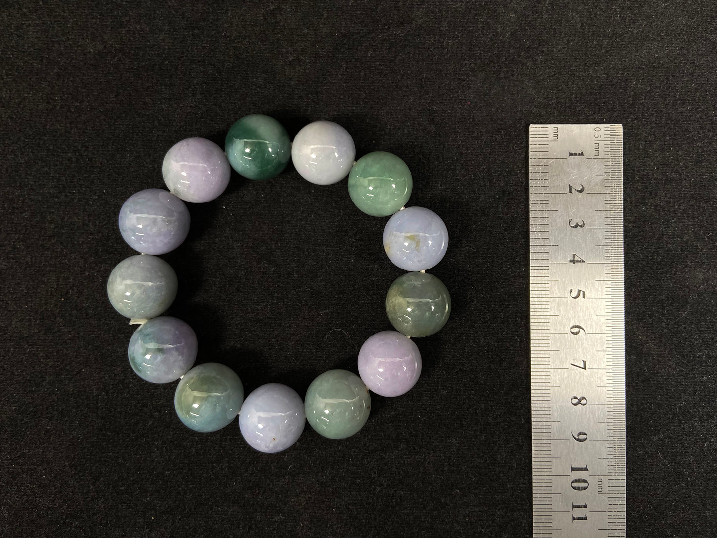 A beaded jadeite bracelet featuring purple, blue, light green, and dark green.