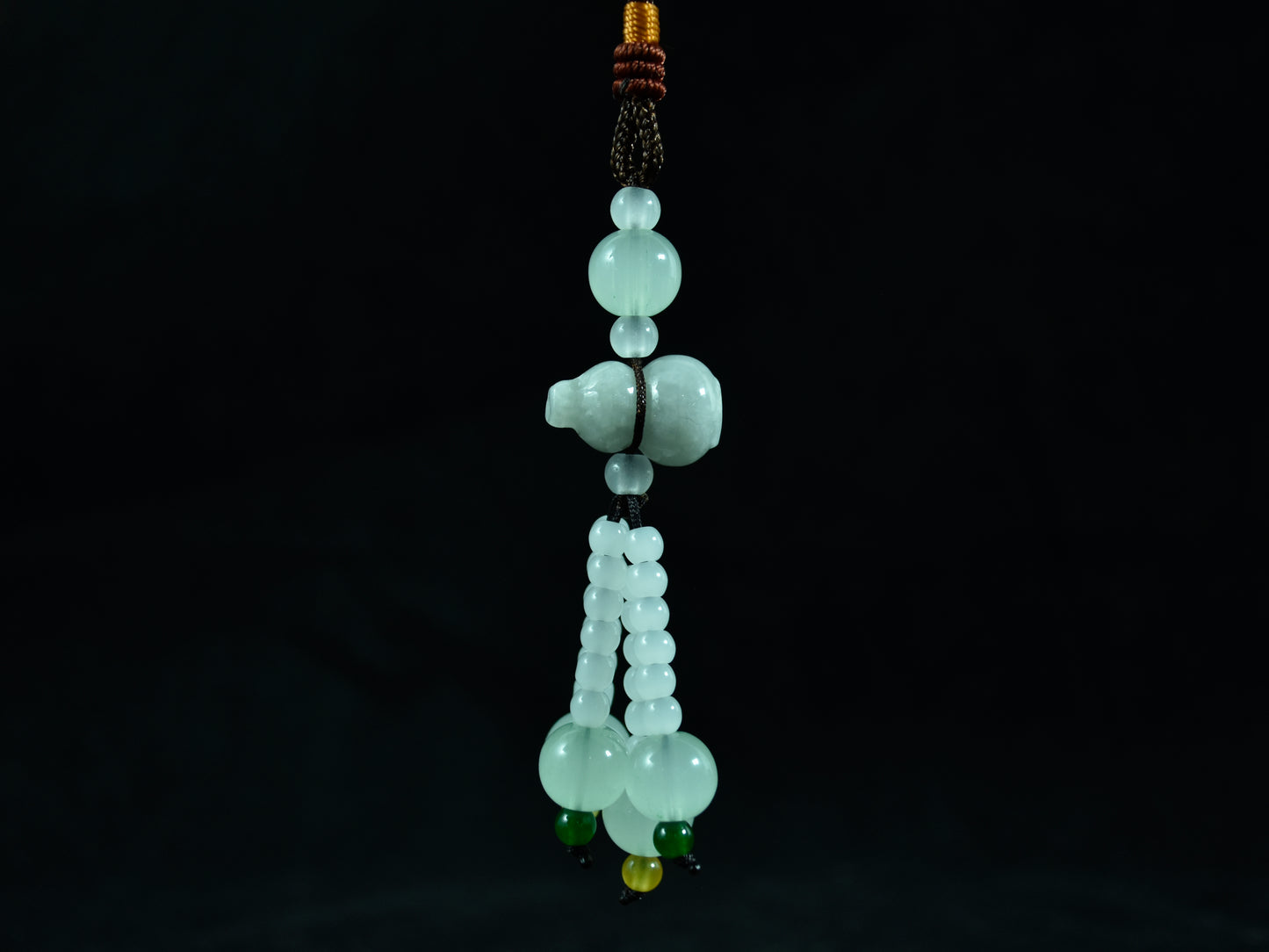 Green jade bead necklace on a black background