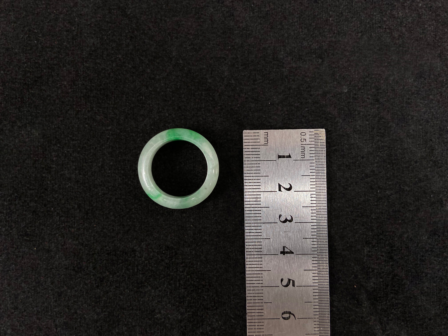 An icy white jadeite ring with natural green accents.