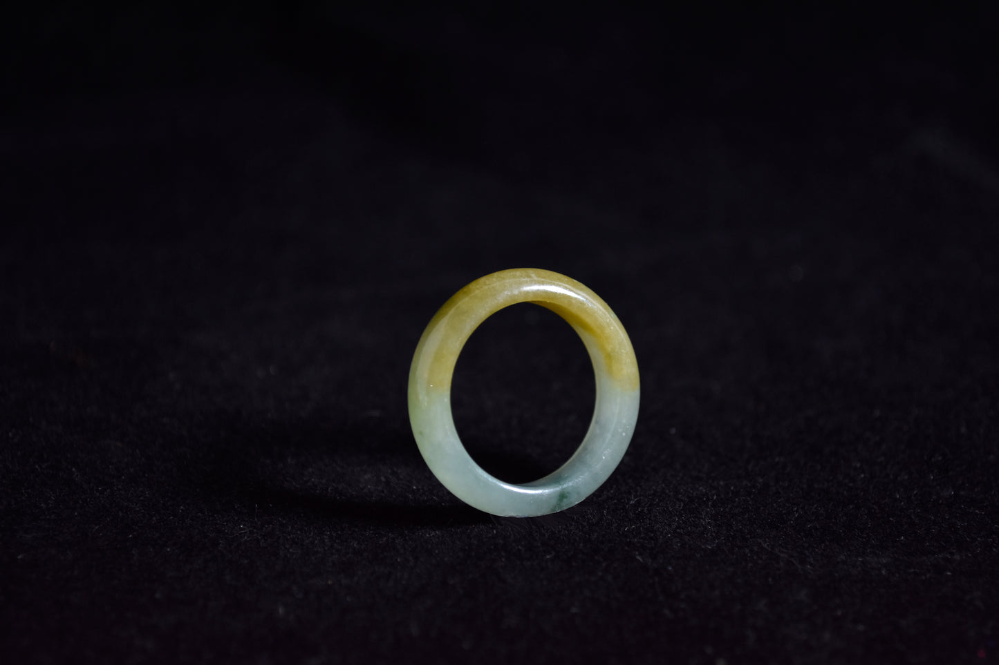 huang fei jade ring on a black background