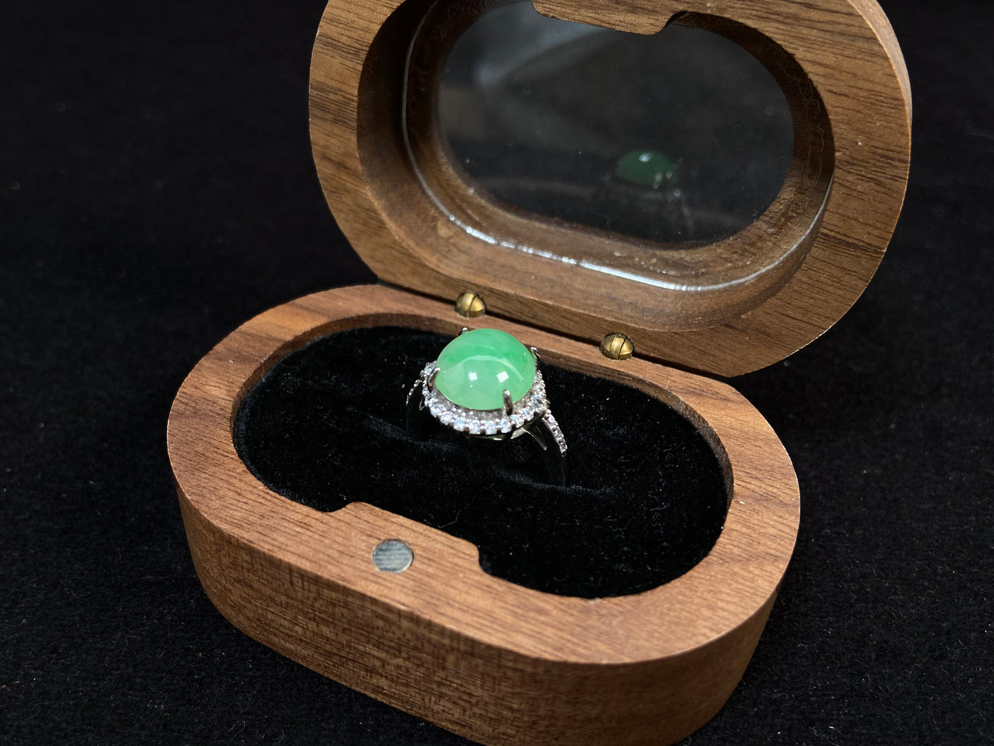 A round apple green jade set in 925 silver with prong setting.