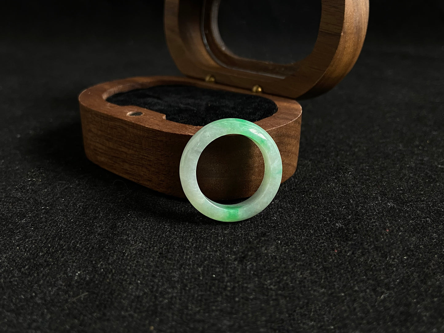 An icy white jadeite ring adorned with two accents of vibrant green.