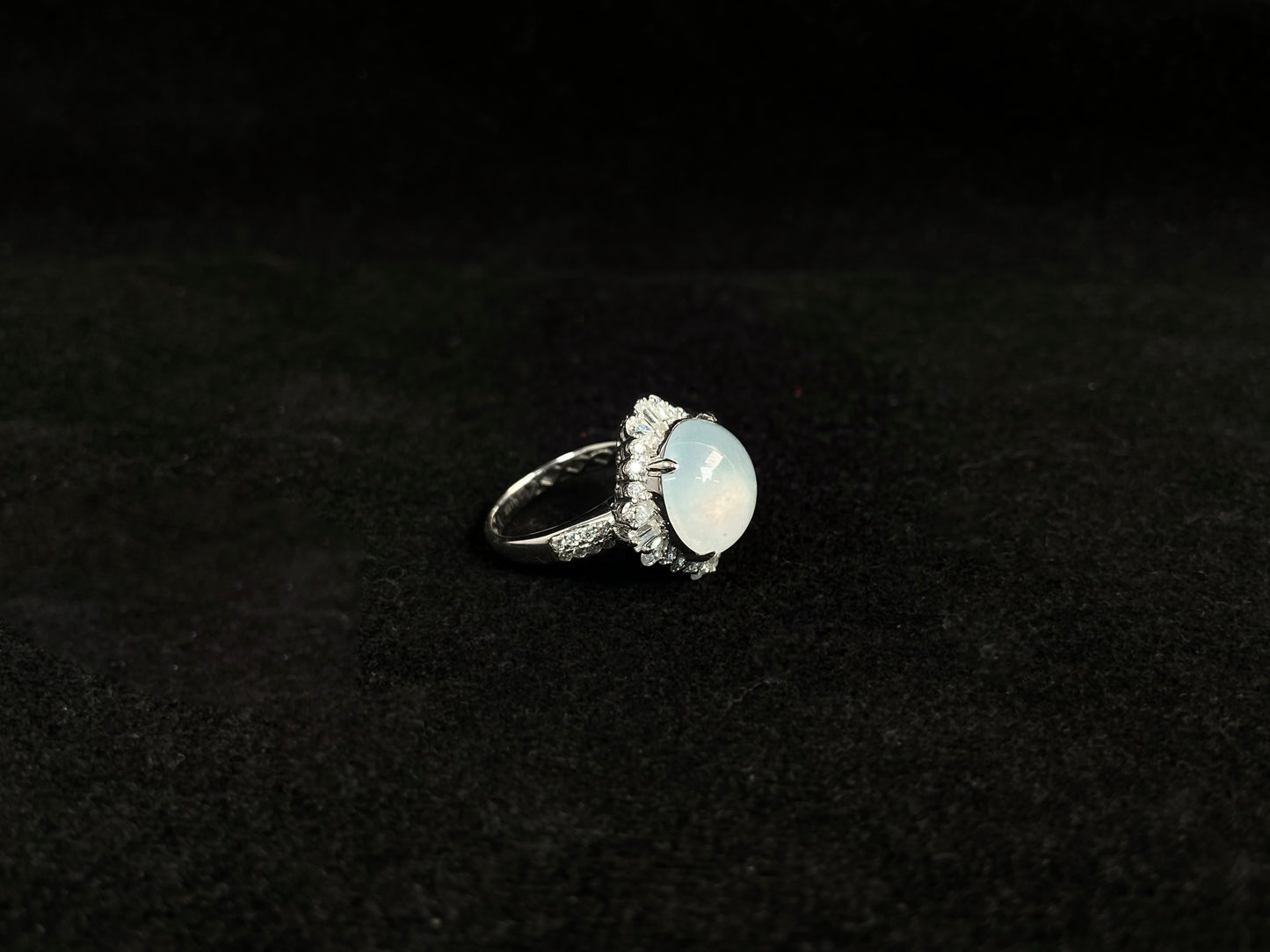 This ring features an icy cabochon jadeite, prong-set and surrounded by a halo of brilliant diamonds.