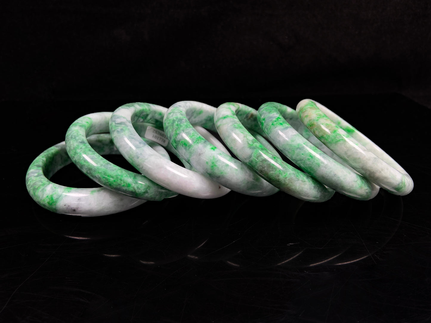A group of white-base green-pattern jadeite bangles.