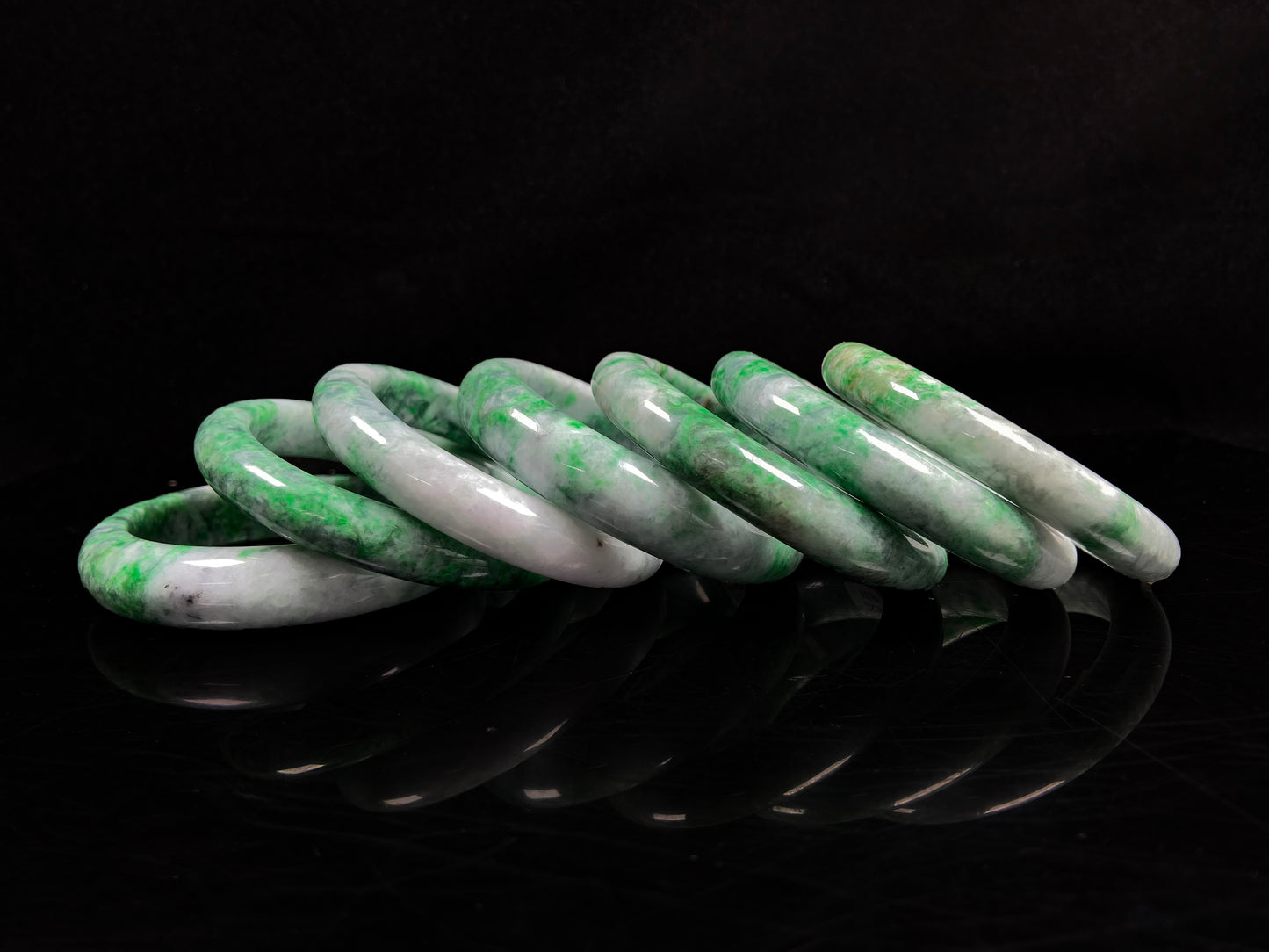 A group of white-base green-pattern jadeite bangles.
