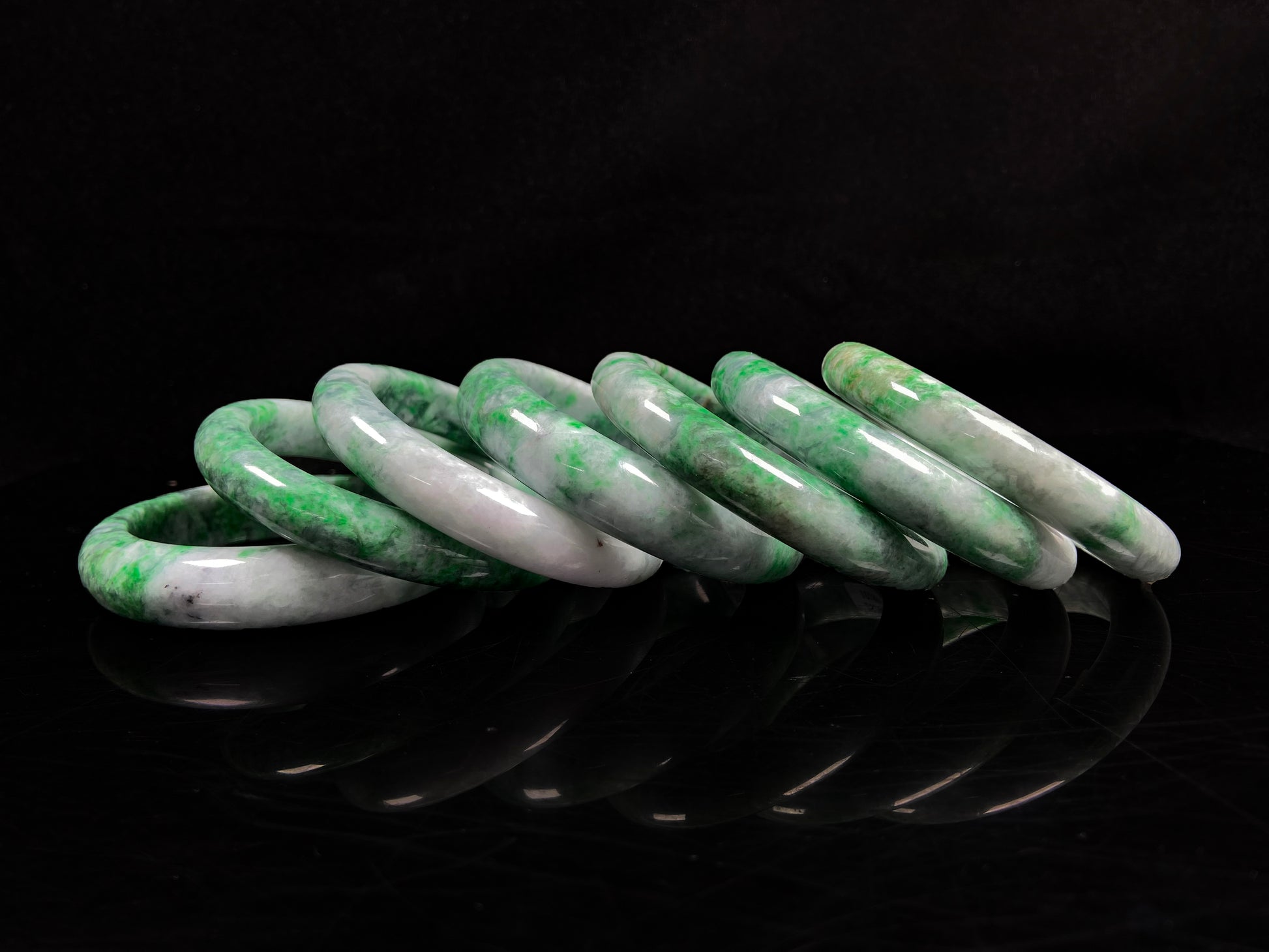 A group of white-base green-pattern jadeite bangles.