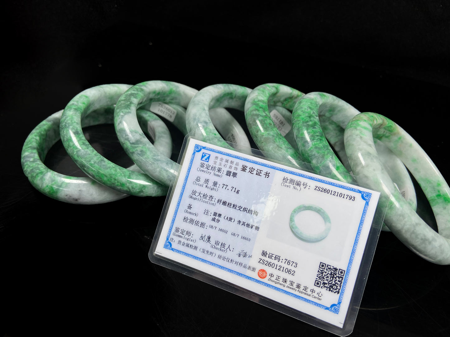 A group of white-base green-pattern jadeite bangles.