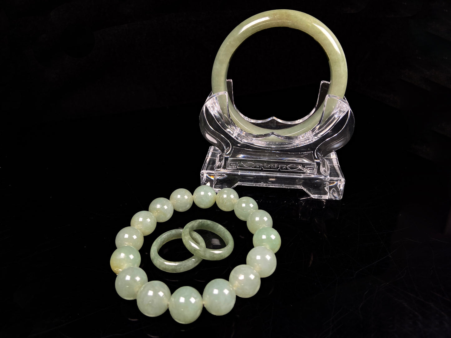 A set of four treasures of verdant glow Natural Burmese Jadeite. It includes a Buddha pendant, a round bangle, a beaded bracelet, and a plain band ring. 