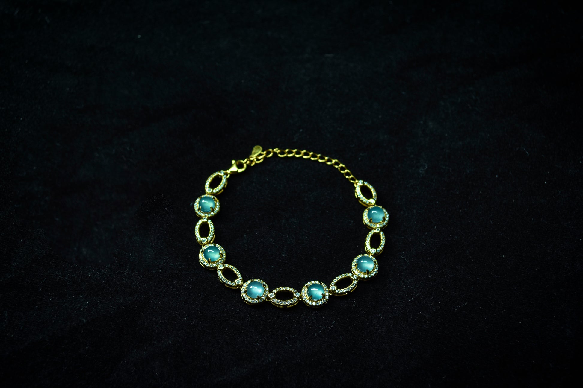 Gold bracelet with turquoise stones on a dark background