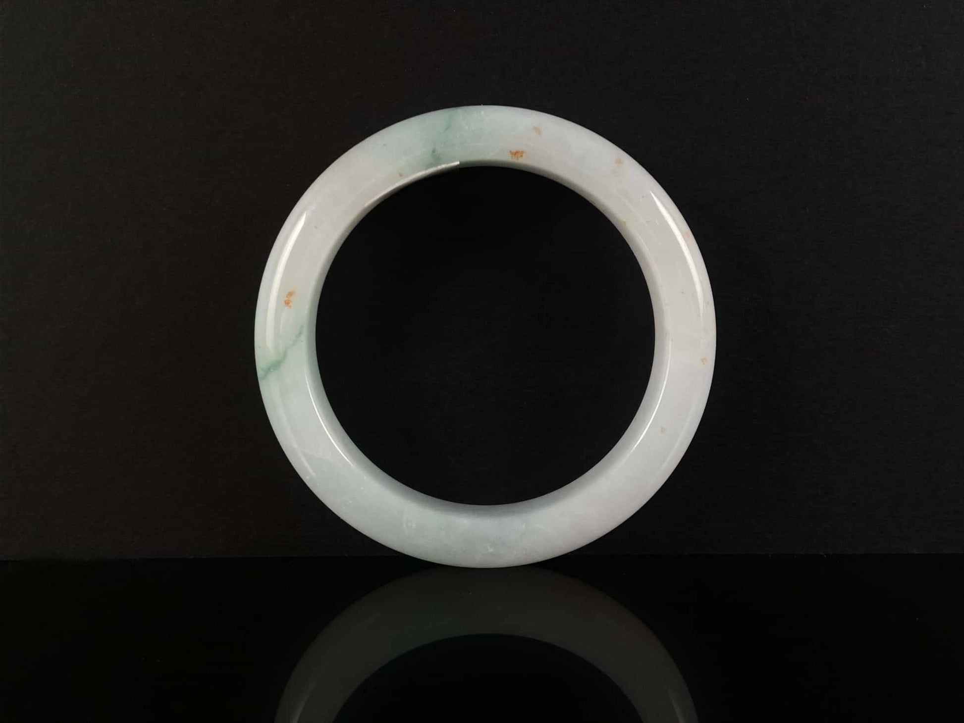 A soft white with red and green jadeite bangle.