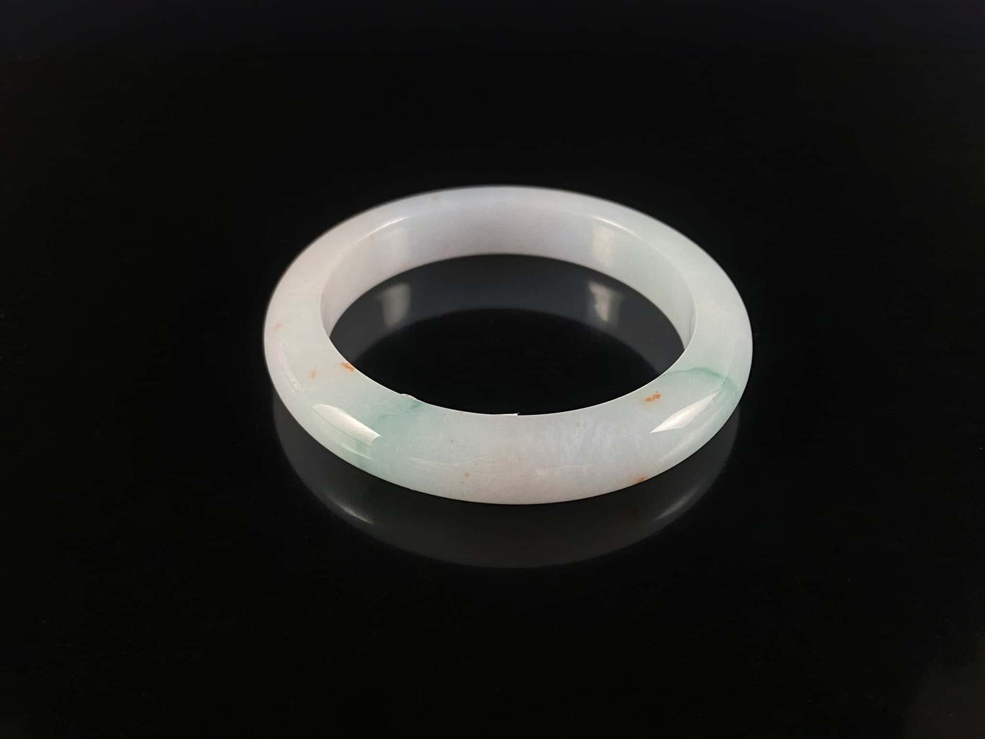 A soft white with red and green jadeite bangle.
