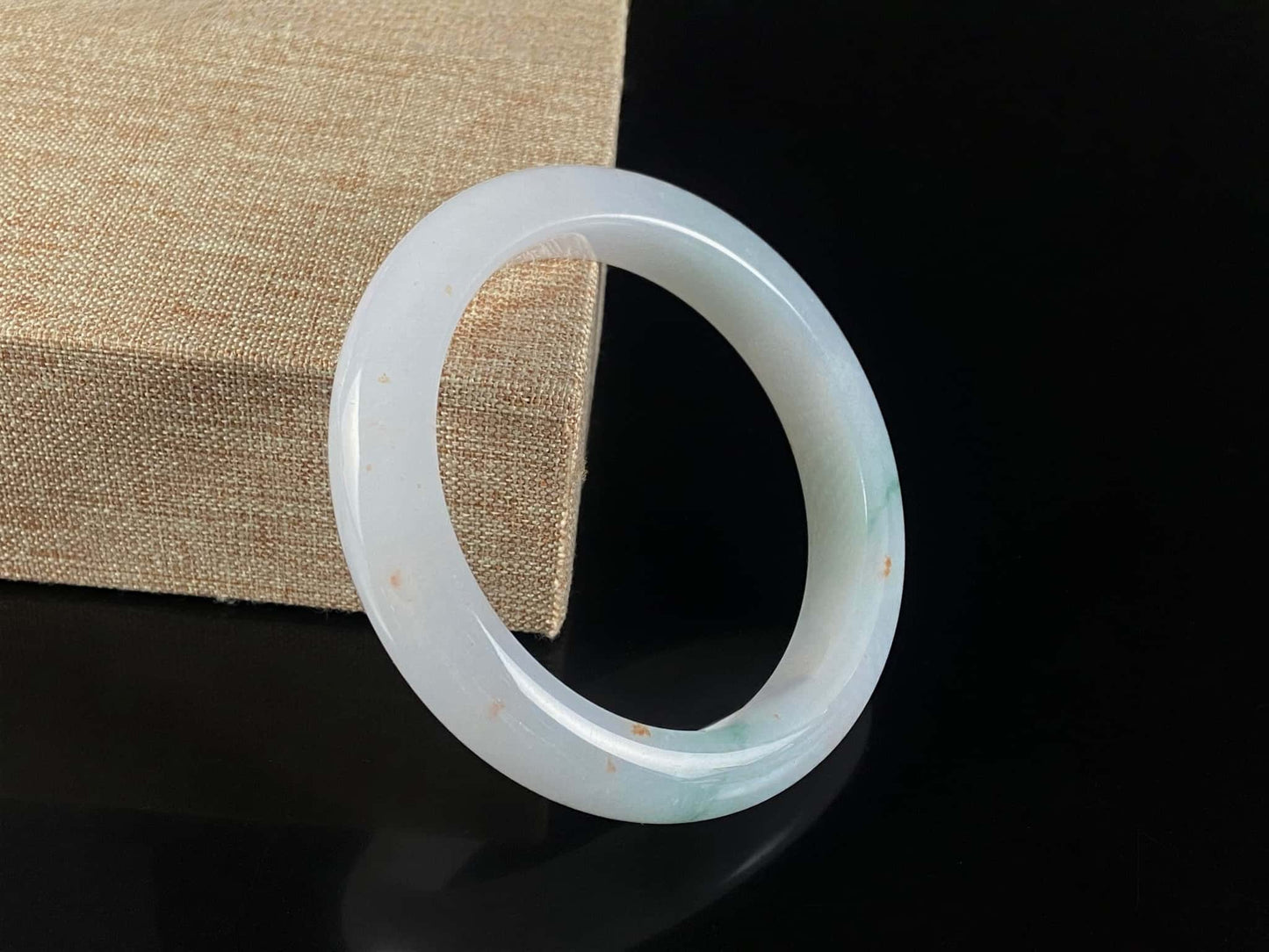 A soft white with red and green jadeite bangle.