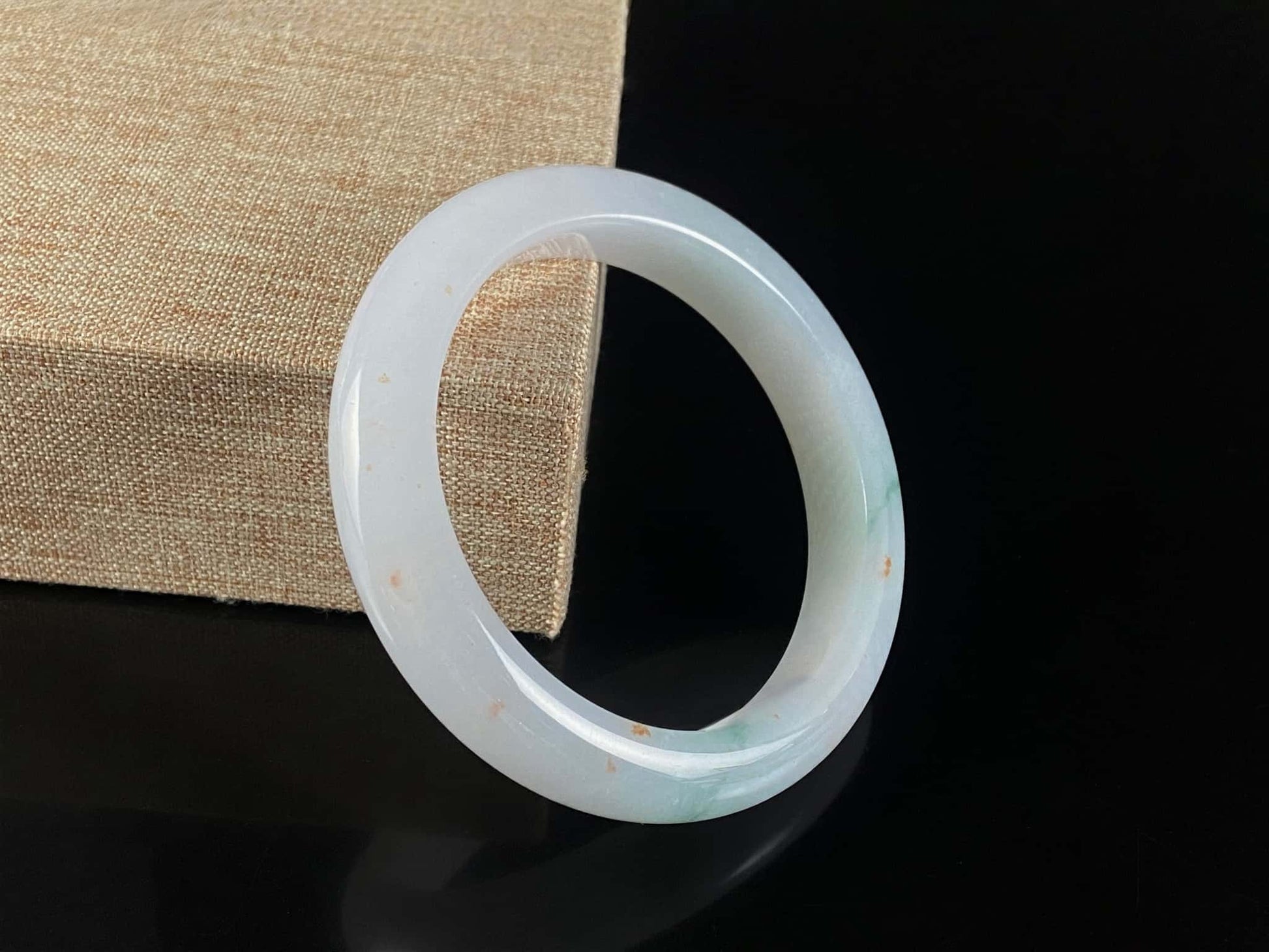 A soft white with red and green jadeite bangle.