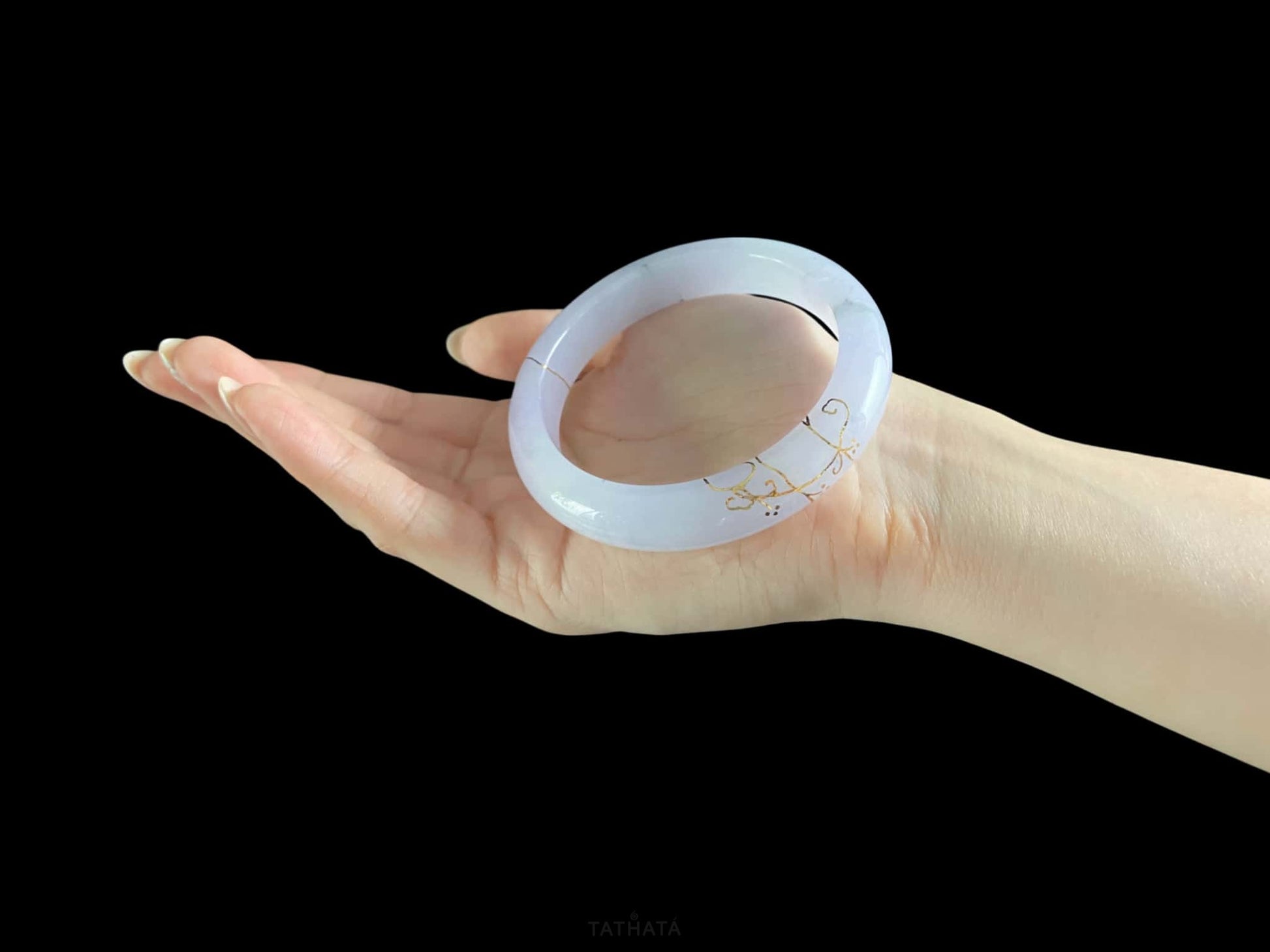 A pale violet golden stitch jadeite bangle.
