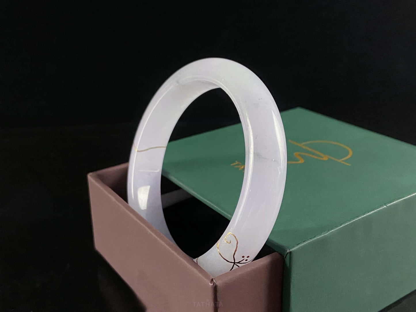 A pale violet golden stitch jadeite bangle.