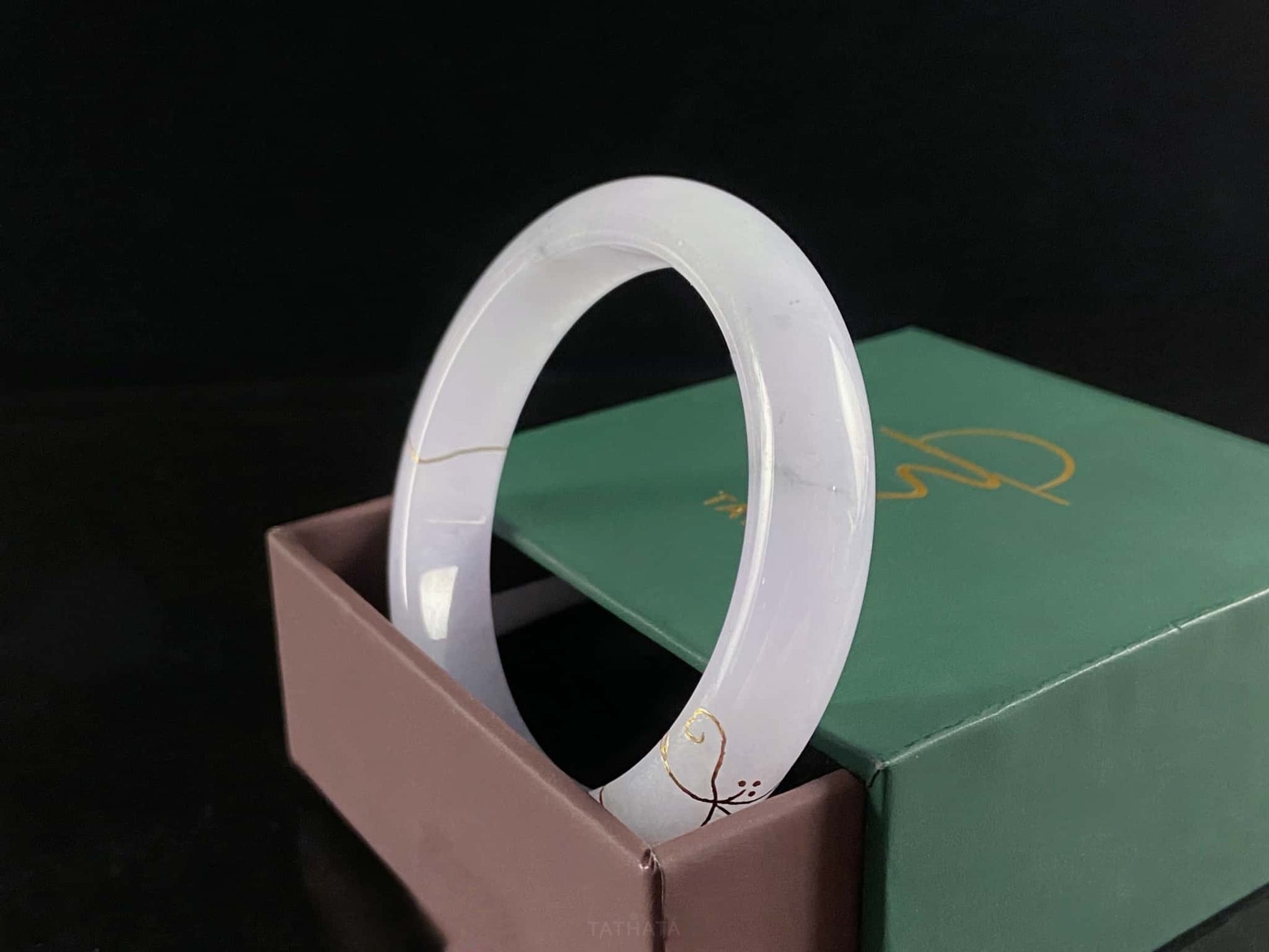 A pale violet golden stitch jadeite bangle.