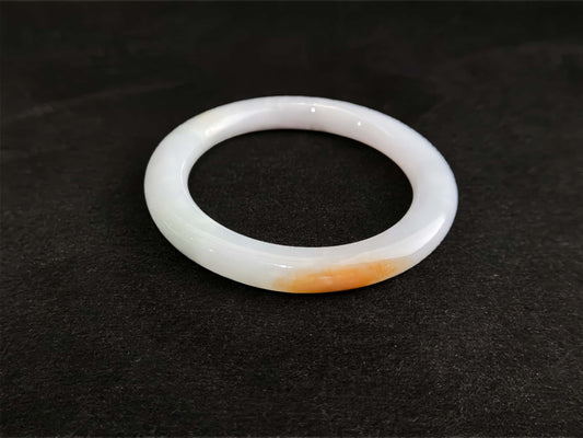 A pure white warm orange inlay jadeite bangle.