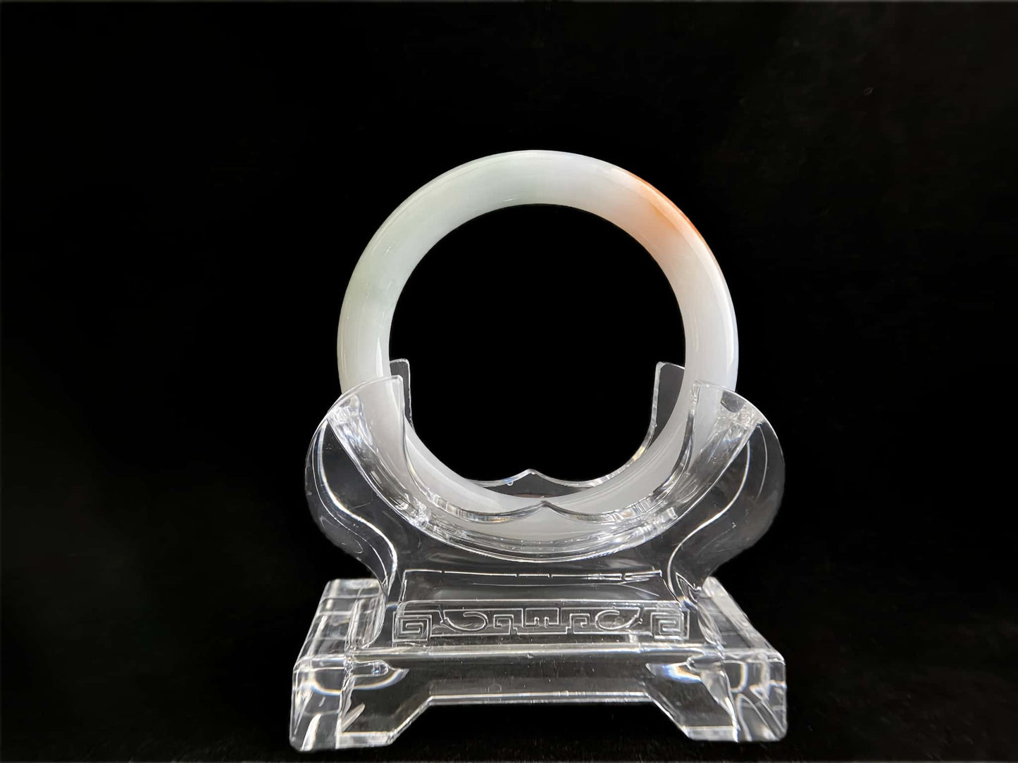 A pure white warm orange inlay jadeite bangle.