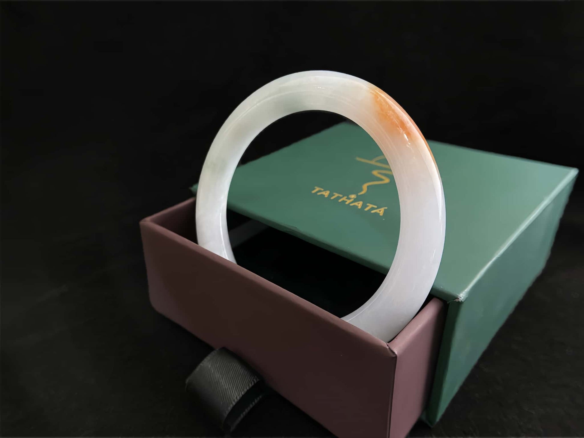 A pure white warm orange inlay jadeite bangle.