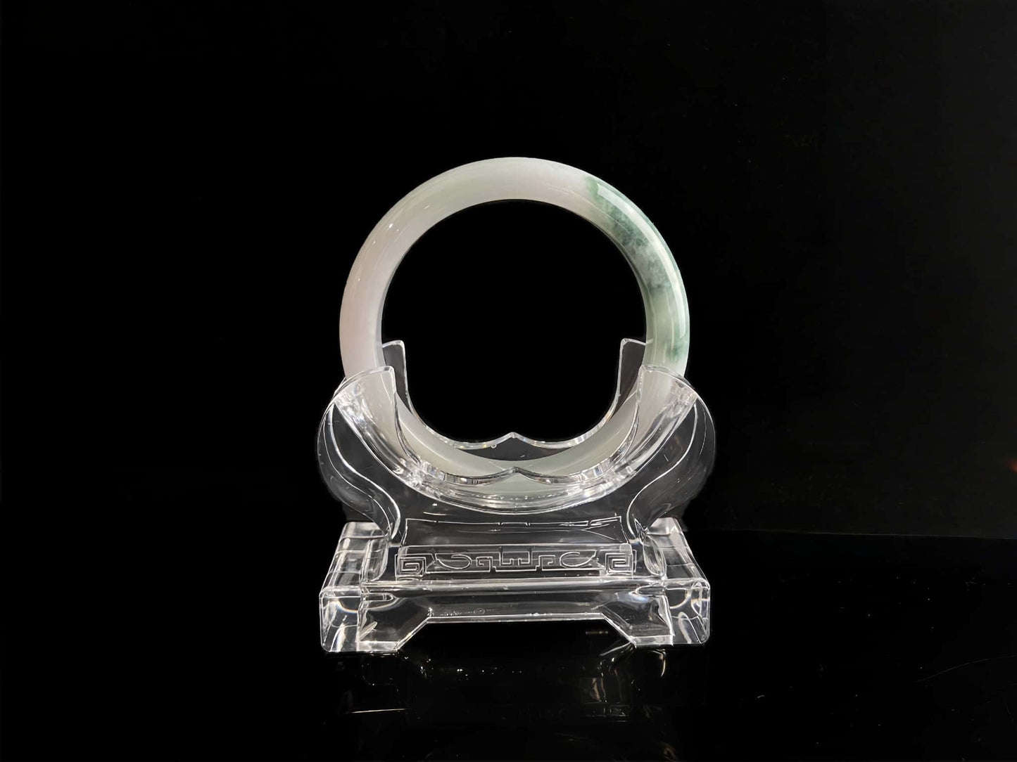 A snow white with green splash jadeite bangle.