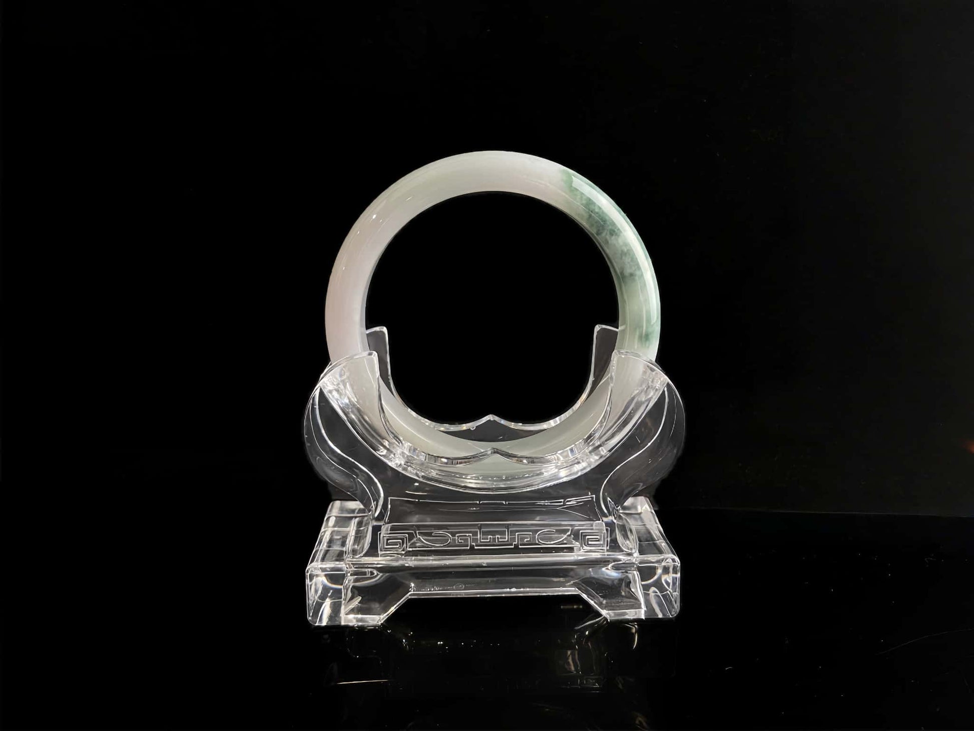 A snow white with green splash jadeite bangle.