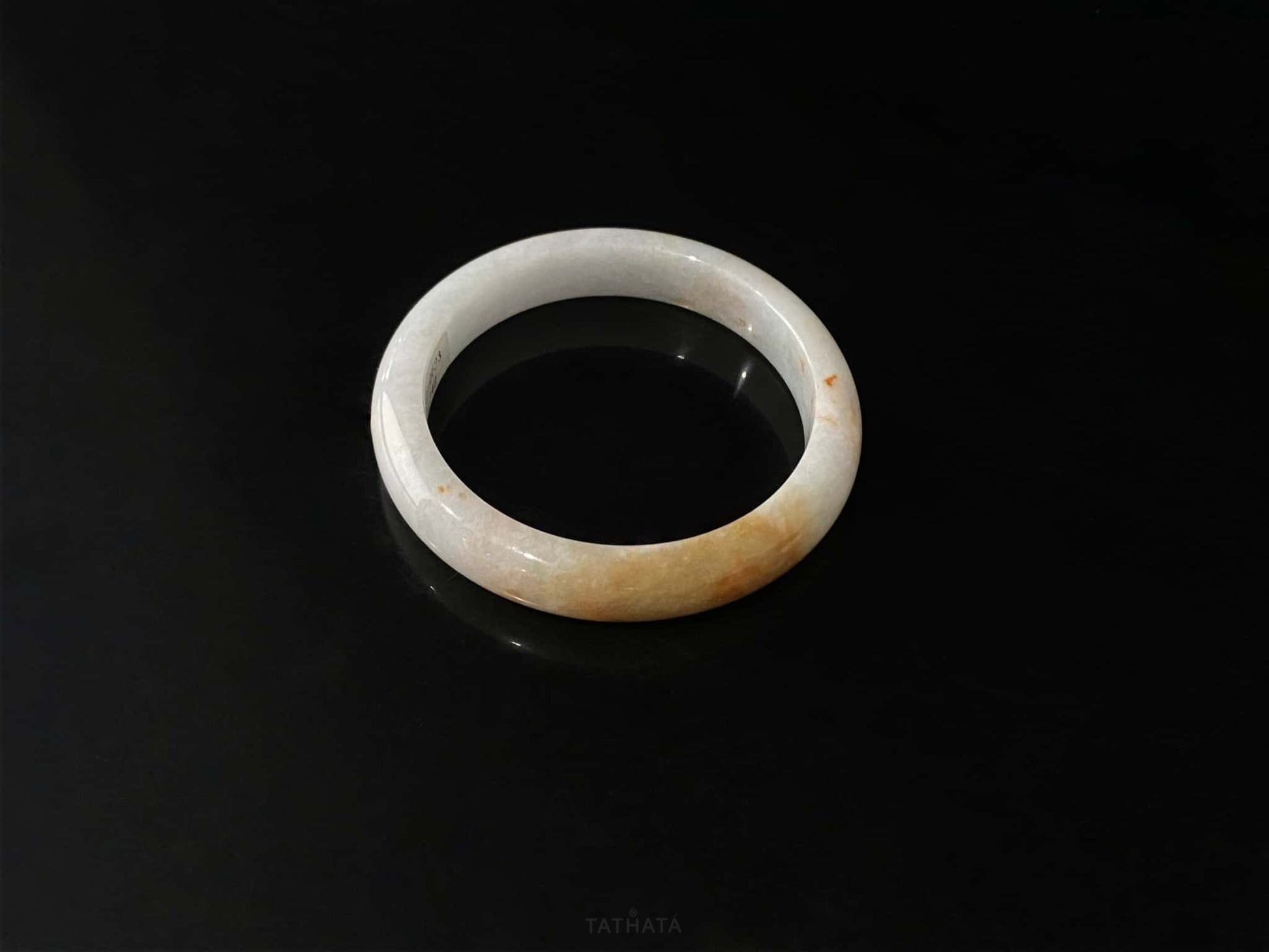 A amber dawn vein jadeite bangle.