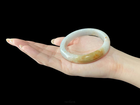 A amber dawn vein jadeite bangle.