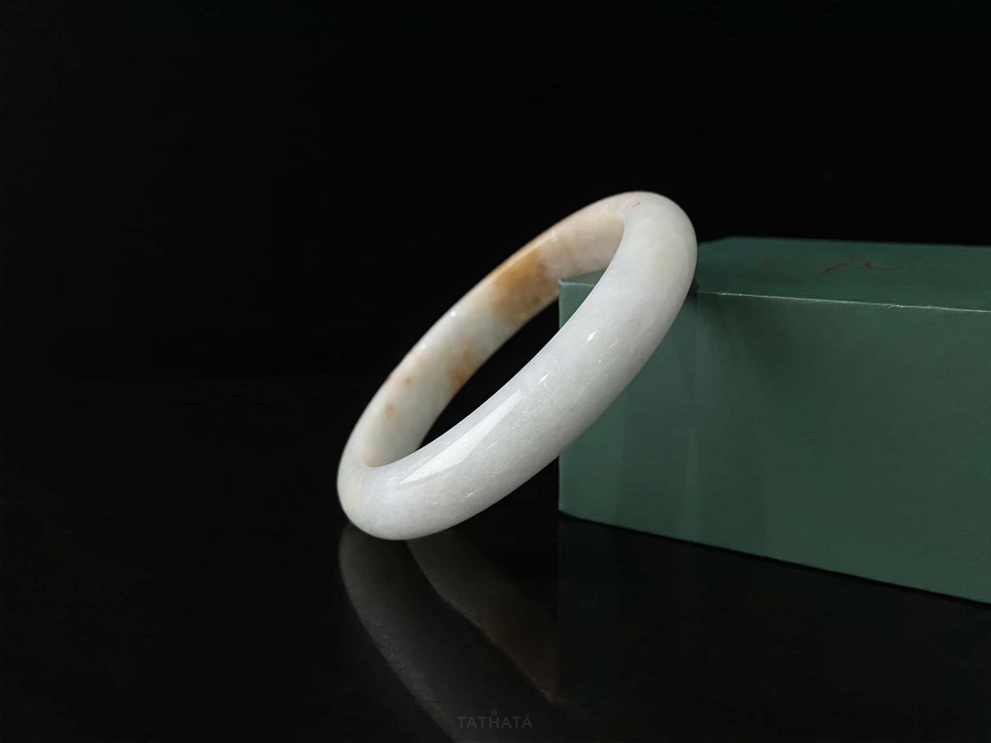 A amber dawn vein jadeite bangle.
