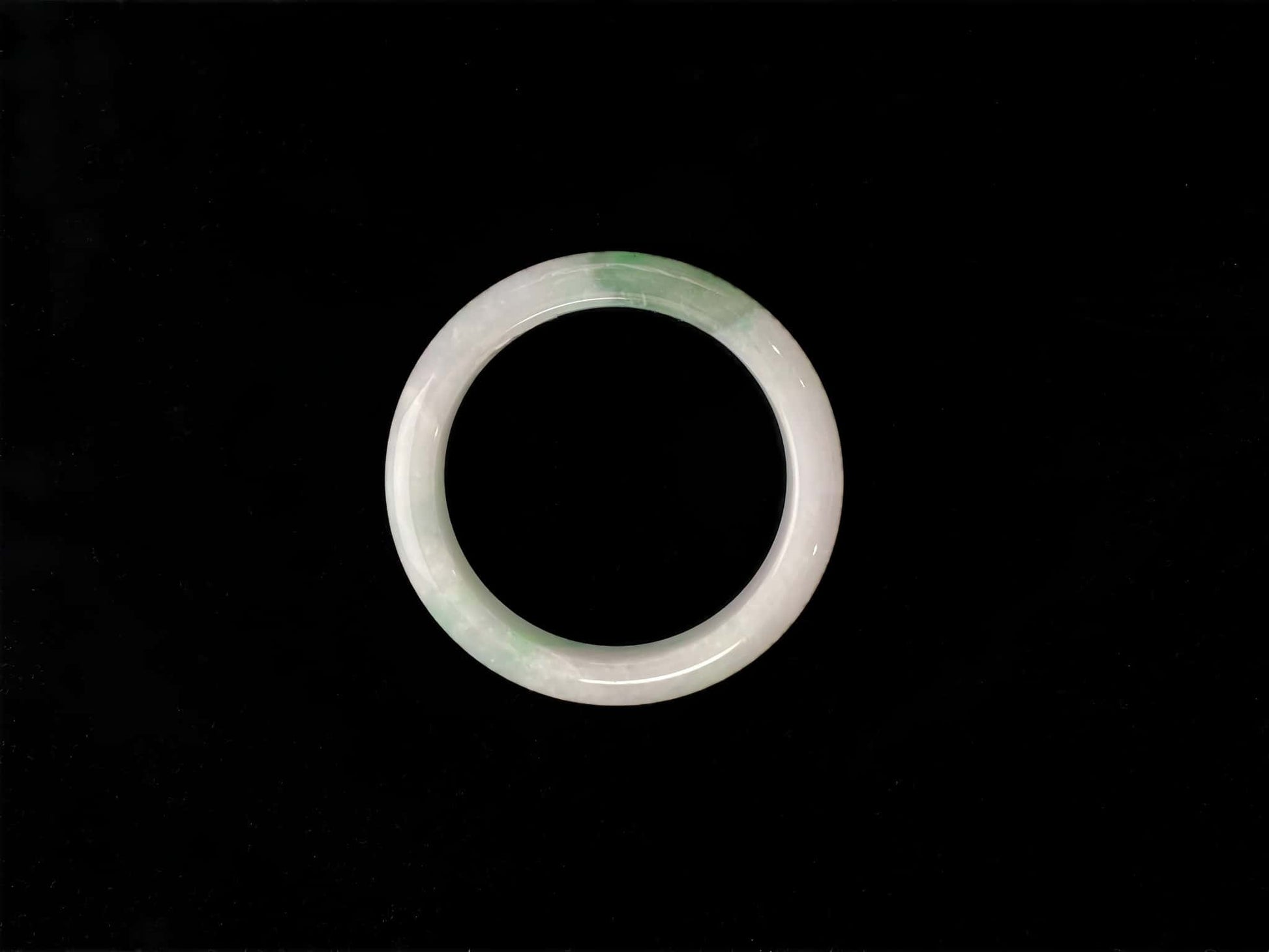 A cloud white and floating green jadeite bangle.