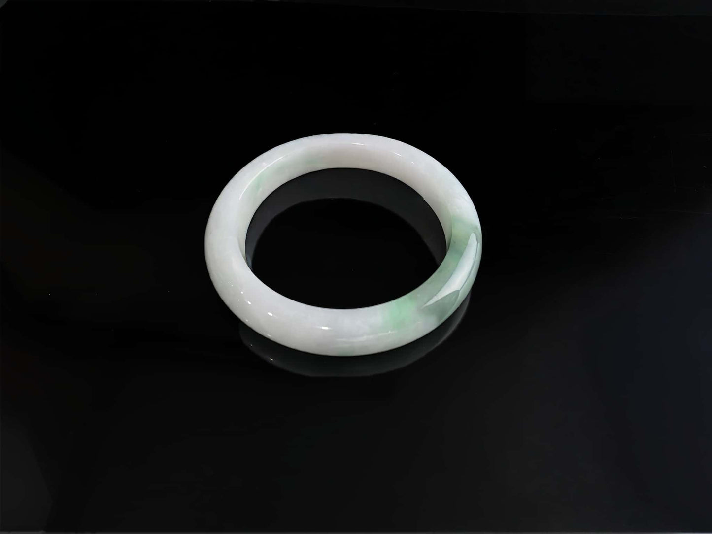 A cloud white and floating green jadeite bangle.