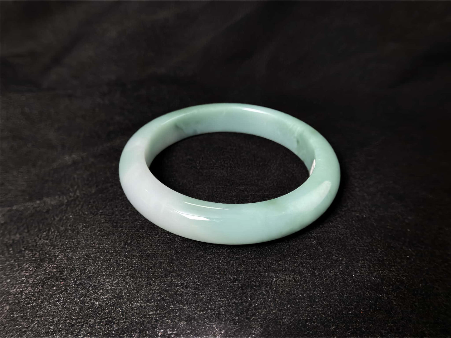 A white base mint green veil jadeite bangle.