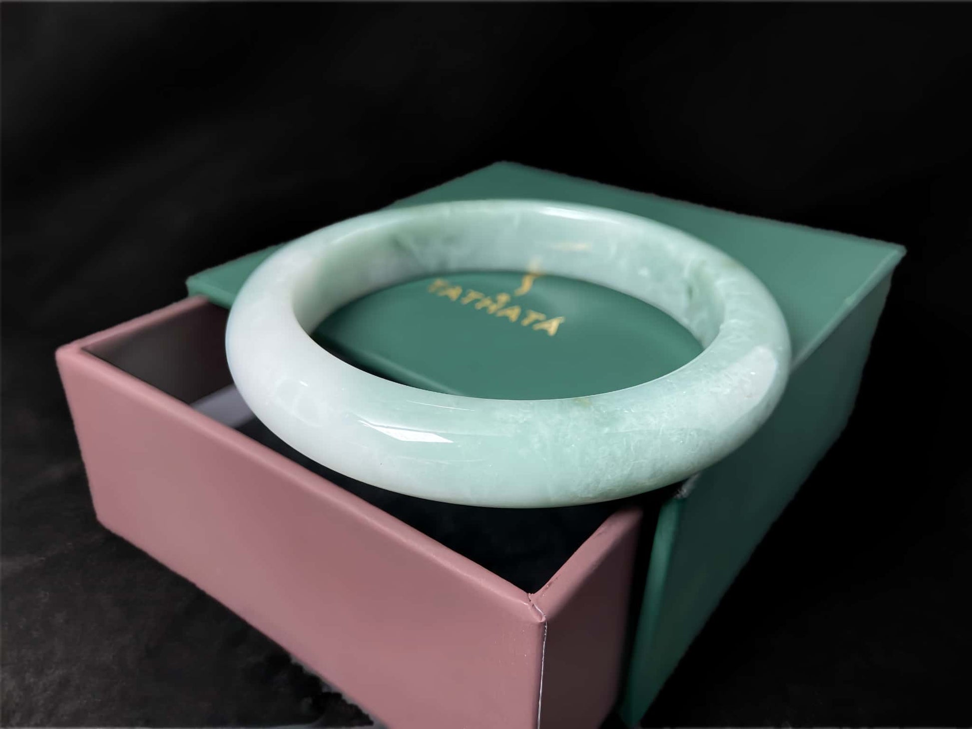 A white base mint green veil jadeite bangle.