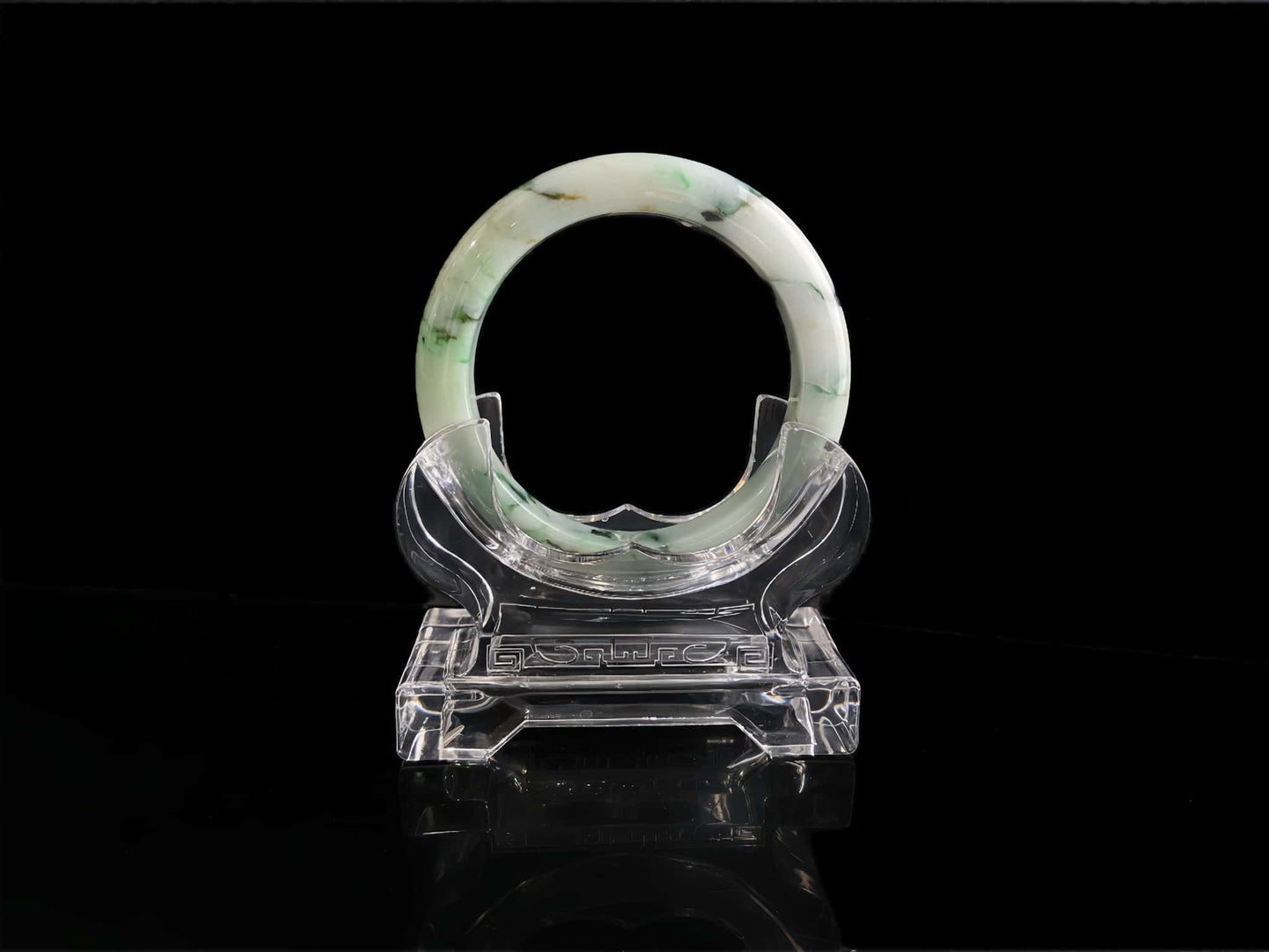 A white base with multi-colored inclusions jadeite bangle.