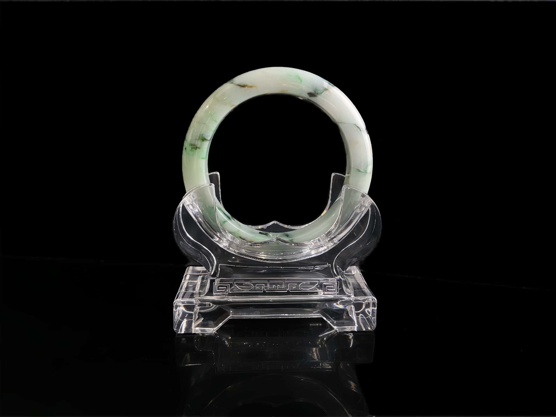 A white base with multi-colored inclusions jadeite bangle.