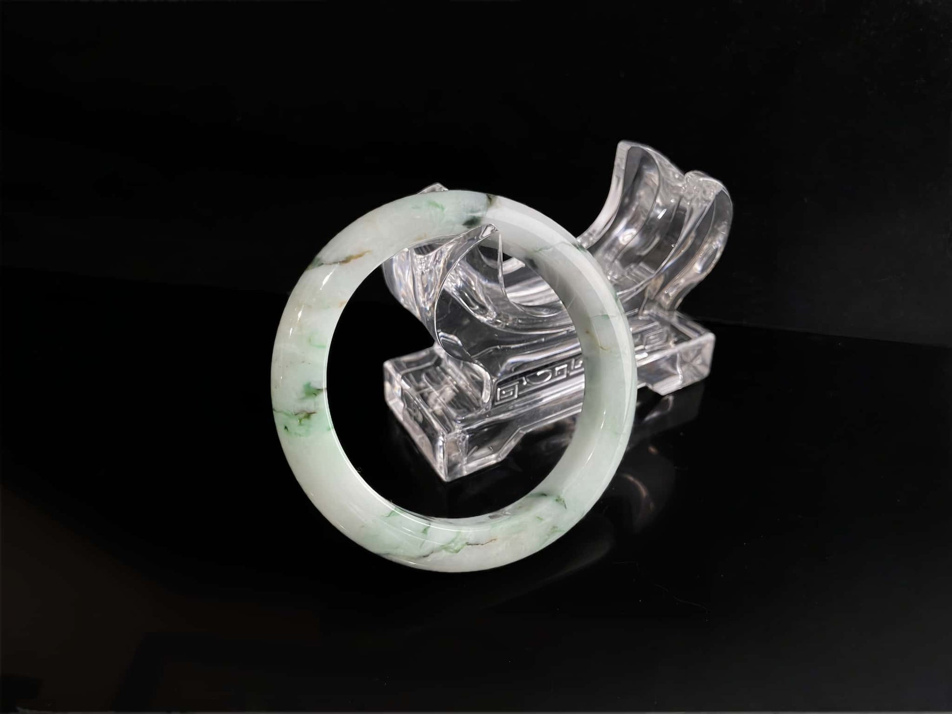 A white base with multi-colored inclusions jadeite bangle.