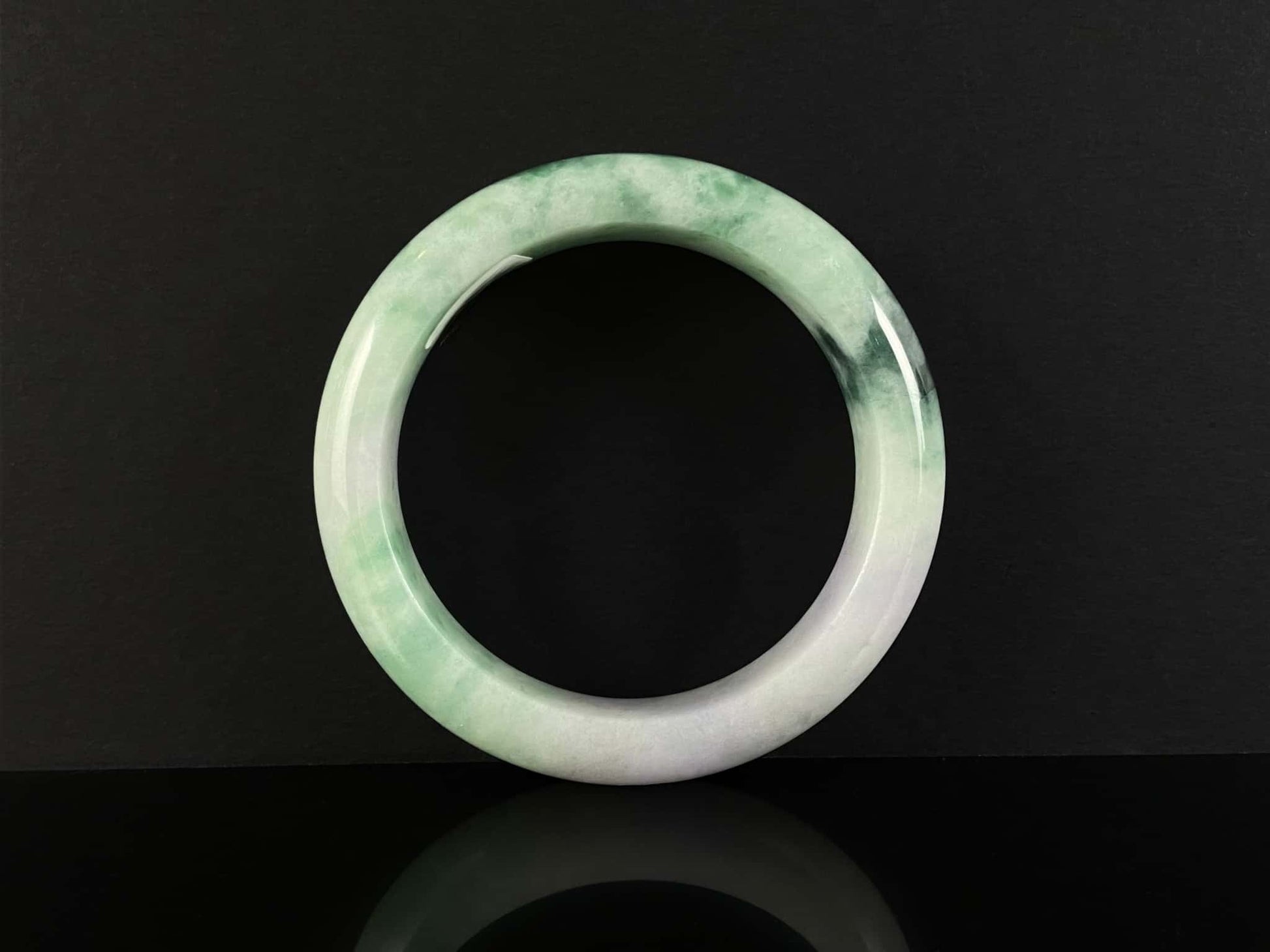 A soft lavender with green swirl jadeite bangle.