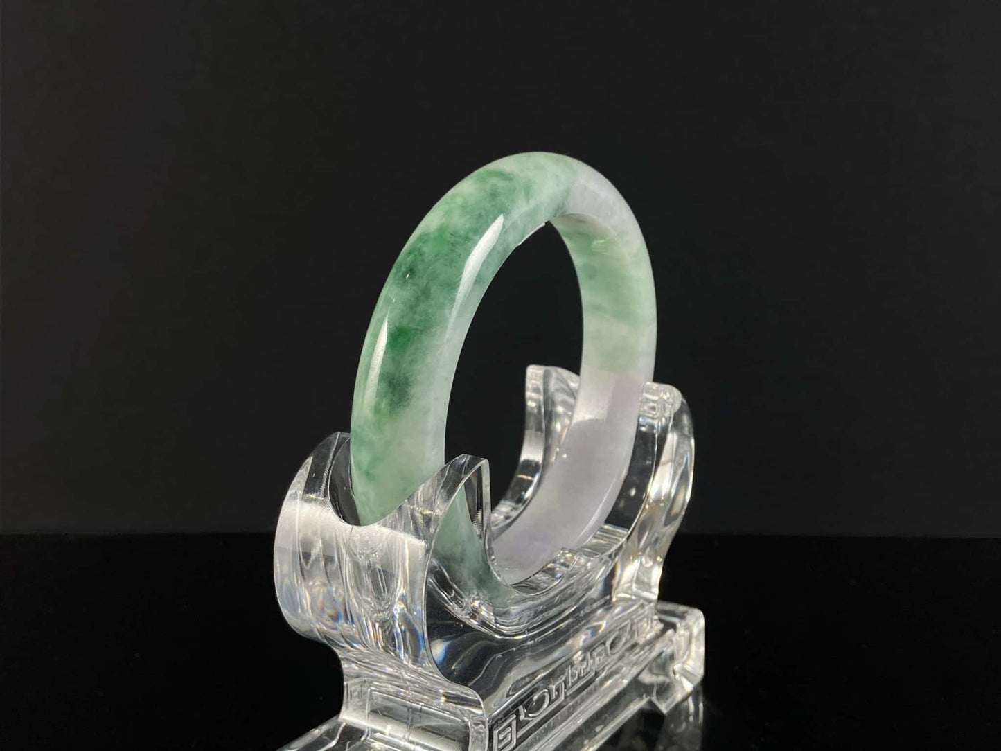 A soft lavender with green swirl jadeite bangle.