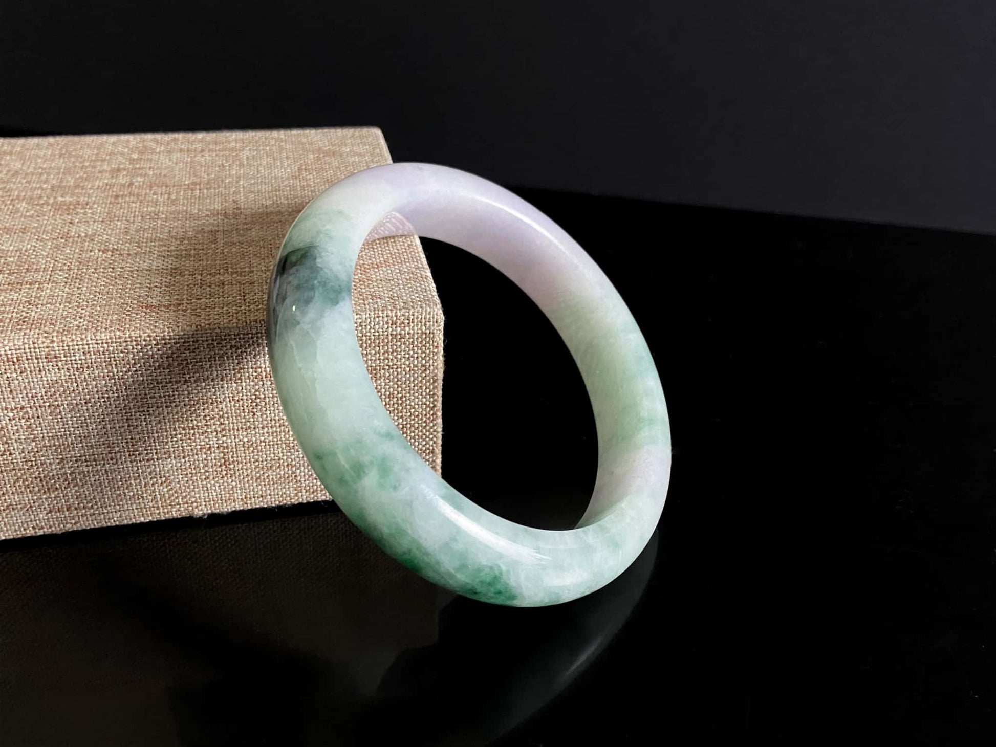 A soft lavender with green swirl jadeite bangle.