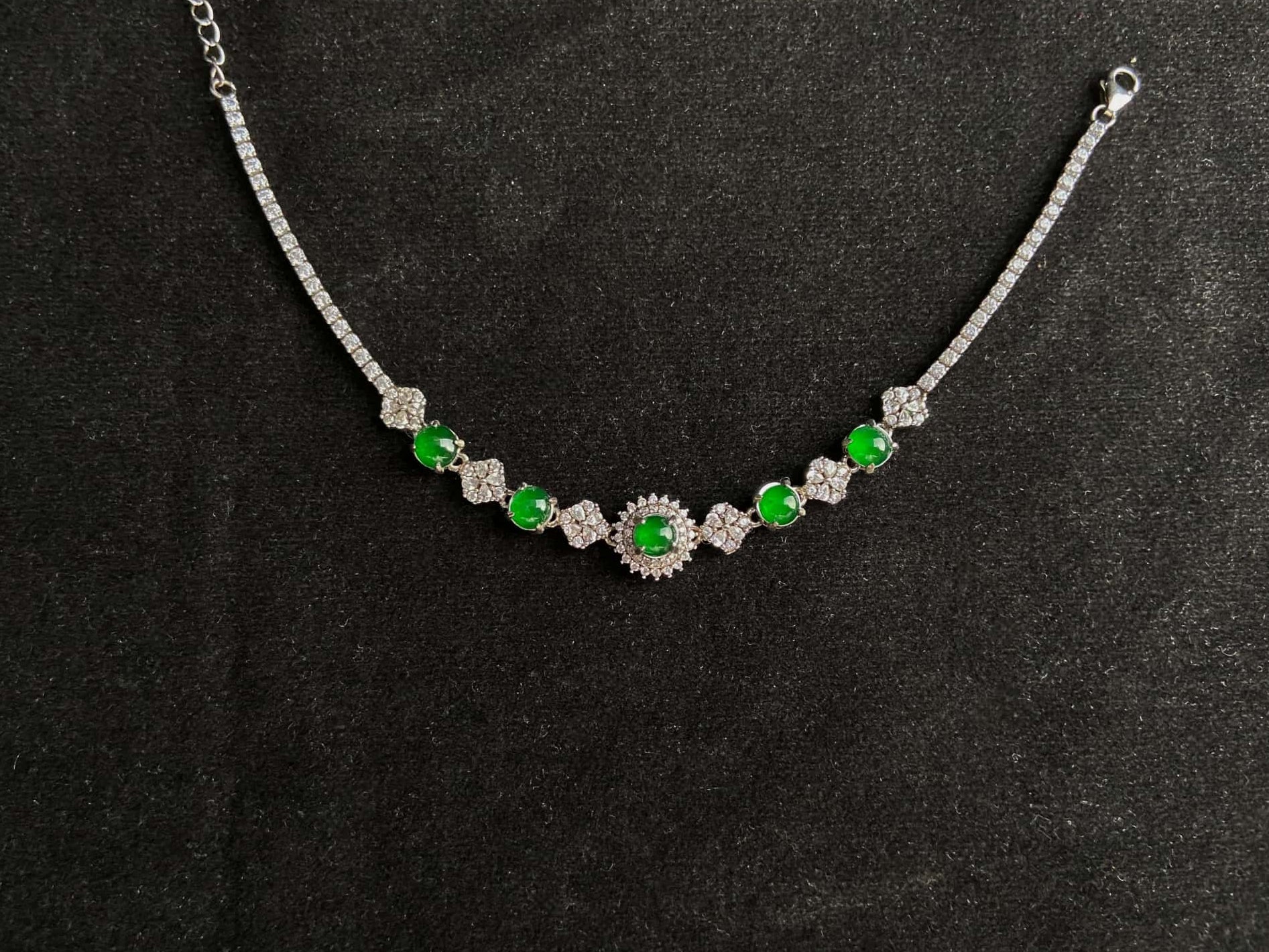 A green sunburst halo jadeite bracelet.
